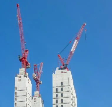 Multiple tower cranes above a concrete structure. Stock Photos