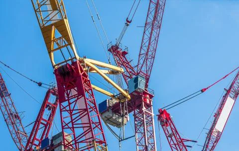 Multiple tower cranes above a concrete structure. Stock Photos