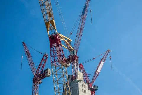 Multiple tower cranes above a concrete structure. Stock Photos