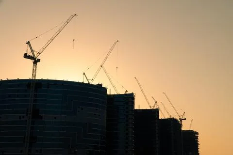 Multiple tower cranes at dusk Stock Photos