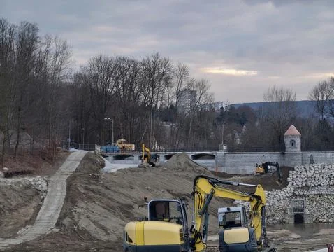 Multiple tracked excavators cooperate diligently to reinforce riverbanks an.. Stock Photos