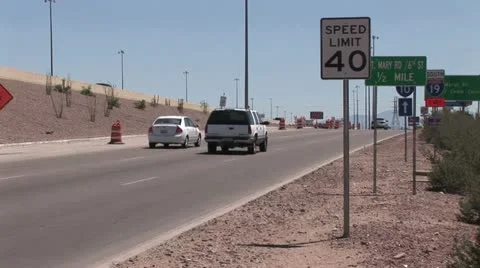 Multiple Traffic Control Signs Along A Freeway On Ramp; Safety Barrels in the Video stock 18974785