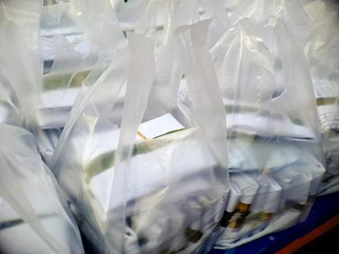 Multiple translucent plastic bags hold various white and light colored item.. Stock Photos