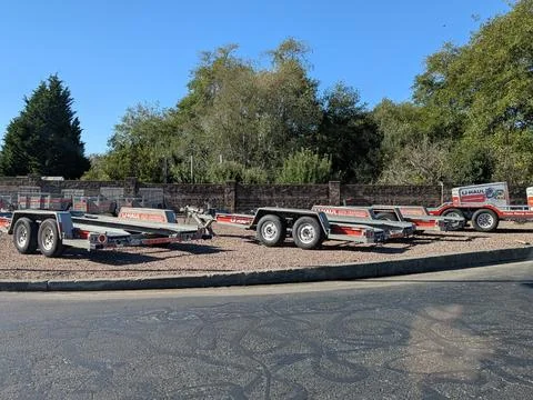 Multiple U-Haul trailers in different sizes, enclosed and open, parked outdoors Stock Photos