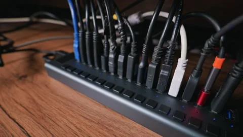 Multiple USB Cables Plugged Into A Black Hub On a Wooden Office Desk Stock Footage 331138116