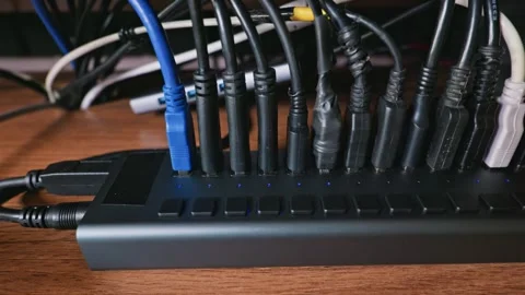 Multiple USB Cables Plugged Into A Powered Hub On a Wooden Desk Stock Footage 331129494