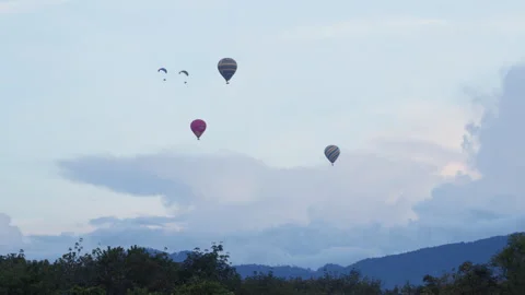 Multiple vibrant hot air balloons active paramotor paragliders gracefully float 스톡 동영상 318202820