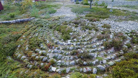 Multiple views of a stone labyrinth nestled amidst greenery and rocks in Ra.. Stock Footage 300798100