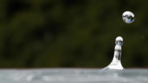 Multiple water drops fall and bounce on a liquid surface in slow motion Stock Footage 144549076
