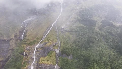 Multiple waterfalls flowing down a misty mountain slope in China, aerial Stock Footage 341845194
