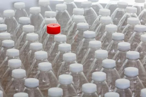 Multiple white capped plastic bottles with one red Foto stock