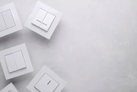 Multiple white light switches on a plain wall Stock Photos
