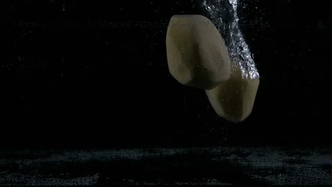 Multiple white peeled potatoes dropped falling in water with lot of splashes Stock Footage 148736651