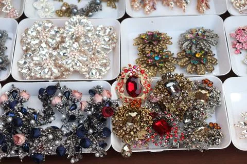 Multiple white trays showcase a vibrant array of sparkling rhinestone and cry Foto stock