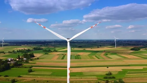 Multiple white wind turbines spinning over rural agricultural fields Video stock 342591491