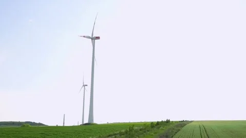 Multiple wind turbines in an expansive green field, showcasing renewable energy Stock Footage 281017911