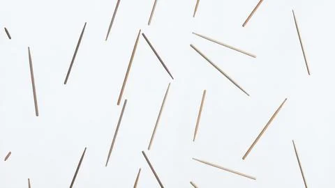Multiple wooden sticks are lying on a white background, forming a seemingly Stock Illustration