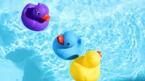 Multiple Yellow Blue and Purple Rubber Duck Toys Floating on Water 4K Stock-Footage 332134821