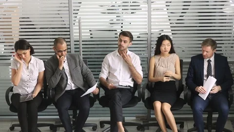 Multiracial applicants sitting in chair in queue wait job interview Video stock 118704788