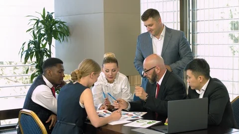Multiracial business team analyzing the graphs in the office Stock Footage 101537957