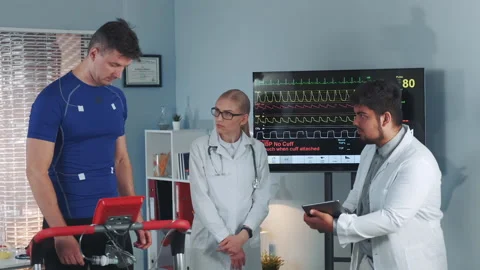 Multiracial cardiologist checking data signals sending by each electrode on Stock Footage 153511231