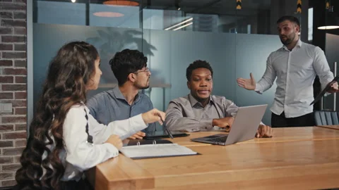 Multiracial colleagues sit in office at table discuss project ideas angry Stockbeeldmateriaal 170455251