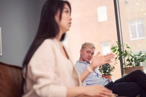 Multiracial couple having argument during psychotherapy session Stock Photos