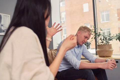 Multiracial couple having argument during psychotherapy session Stock Photos