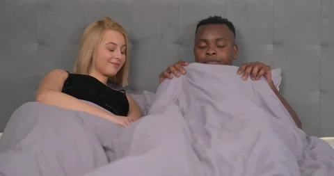 Multiracial couple lying in bed. African man has erectile dysfunction. Male Video stock 153283815