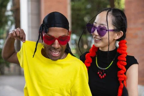 Multiracial couple smiling while dancing together in the street fun Stock Photos
