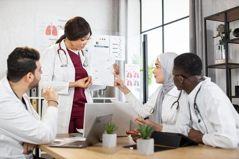Multiracial doctors using gadgets during consilium Stock Photos