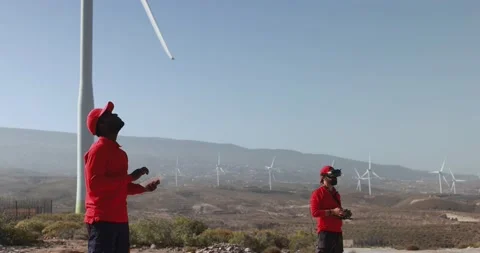 Multiracial engineer men control a drone on site at wind turbines farm Stock Footage 194266608
