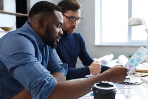 Multiracial engineer team working in office with color palette. Architects Stock Photos