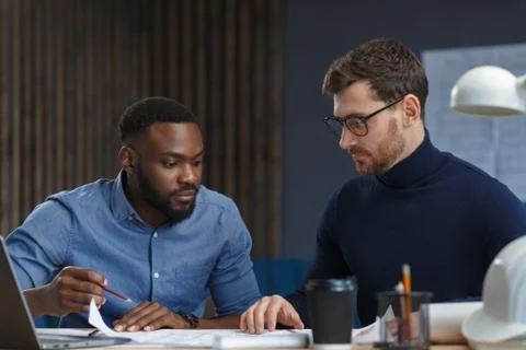 Multiracial engineer team working in office with blue prints and architect Foto stock