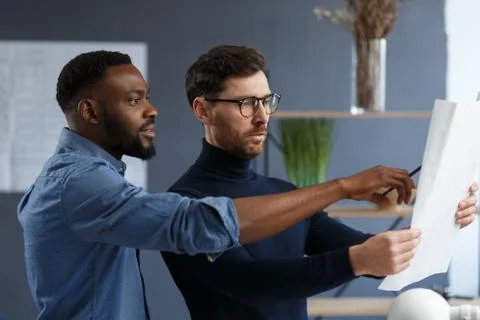 Multiracial engineer team working in office with blue prints and architect Stock Photos