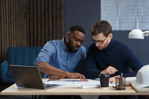 Multiracial engineer team working in office with blue prints and architect Stock Photos