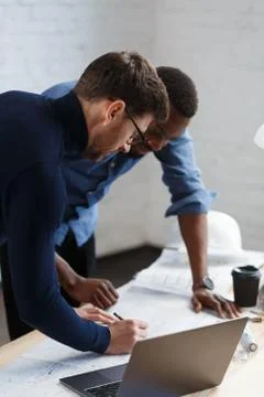 Multiracial engineer team working in office with blue prints and architect Stock Photos