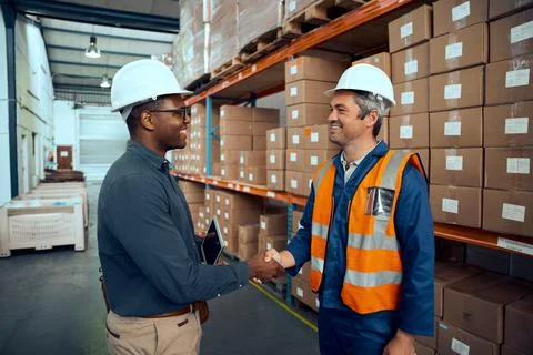 Multiracial engineers shaking hands with each others at manufacturing industry Stock Photos