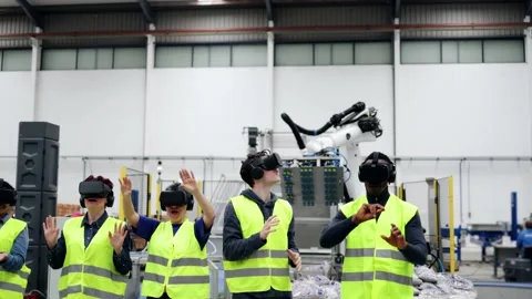 Multiracial engineers using virtual reality headsets while working at robotic fa Stock Footage 229639913
