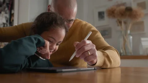 Multiracial father and son with Down syndrome using digital tablet Stock Footage 238844178