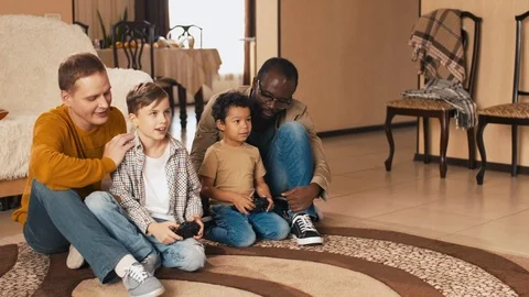 Multiracial fathers and sons playing video games Stock Footage 100690331