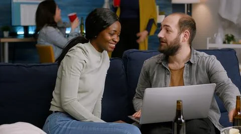 Multiracial friends socializing while watching online videos on laptop Fotos Stock