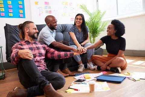 Multiracial group of colleagues put hands together in stack, celebrate teamwork Stock Photos