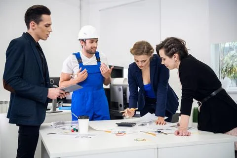 Multiracial group of constructors, builders, engeneers and architects discussing Stock Photos