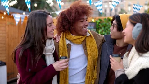 Multiracial group of diverse friends drinking hot drinks in a christmas market Stock Footage 250532161