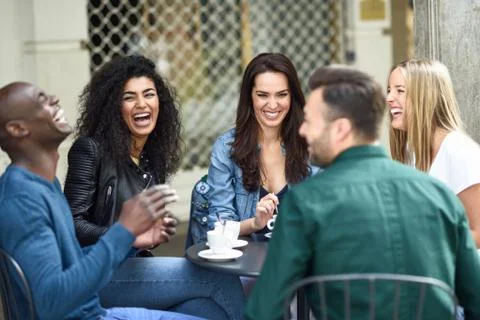 Multiracial group of five friends having a coffee together Stock Photos