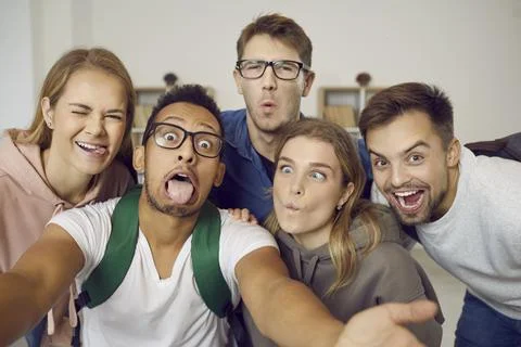 Multiracial group of happy students taking a funny selfie and making crazy faces Stock Photos