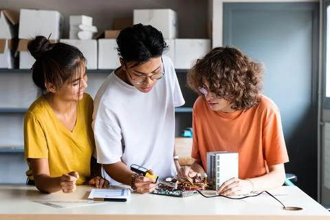 Multiracial group of high school students learn electronics together. Stock Photos