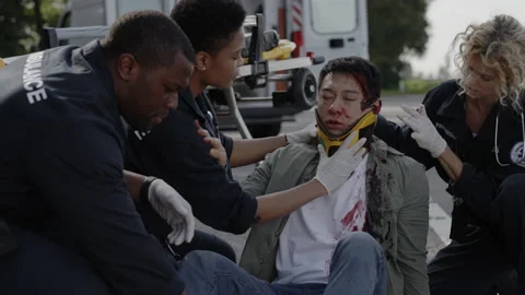 Multiracial group of paramedics helping asian man on road Stock-Footage 163908856