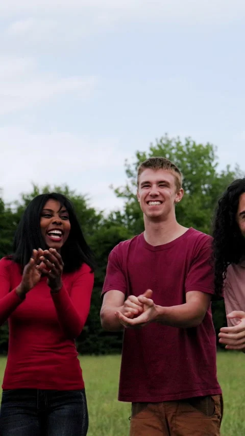 Multiracial group of people celebrating, clapping hands at park city in summer d Stock Footage 280435543